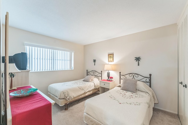 bedroom featuring light carpet and a closet