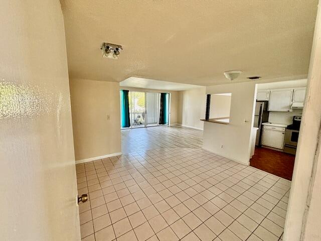 unfurnished room with light tile patterned floors and a textured ceiling