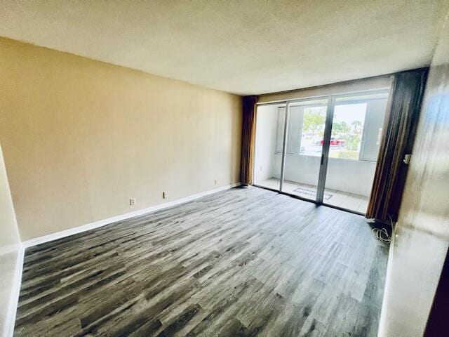 empty room with dark wood-type flooring and a textured ceiling