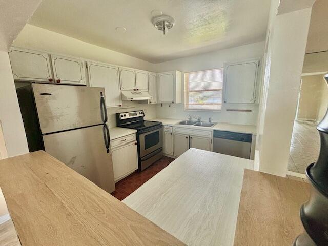 kitchen featuring hardwood / wood-style floors, appliances with stainless steel finishes, white cabinetry, and sink