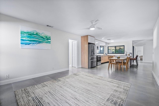 dining room featuring ceiling fan and tile patterned flooring