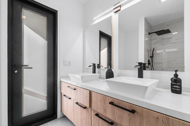 bathroom with tiled shower and vanity