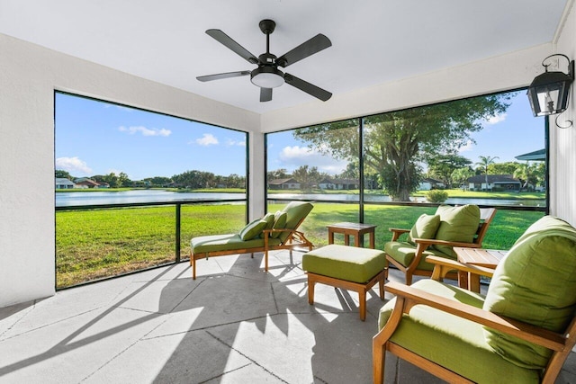 sunroom / solarium featuring a water view and ceiling fan