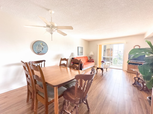 dining space with hardwood / wood-style floors, a textured ceiling, and ceiling fan