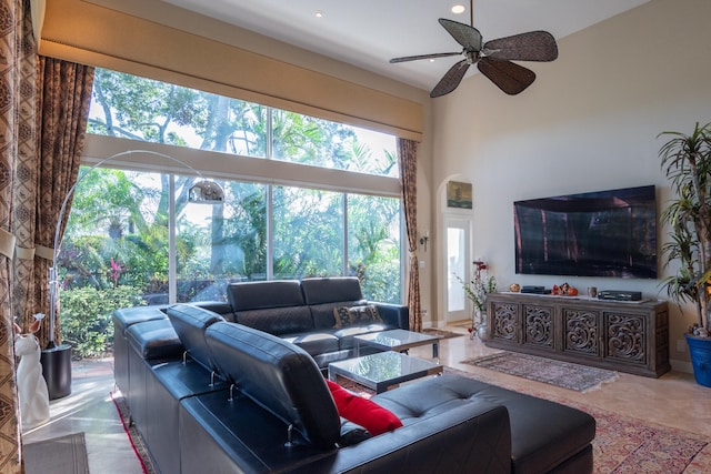 living room featuring ceiling fan and a high ceiling