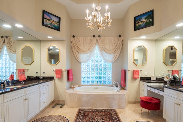 bathroom featuring tiled tub, plenty of natural light, vanity, and a notable chandelier