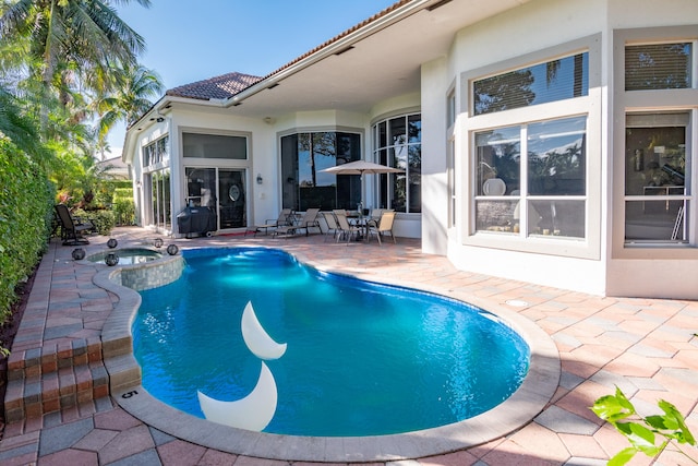 view of pool with an in ground hot tub and a patio