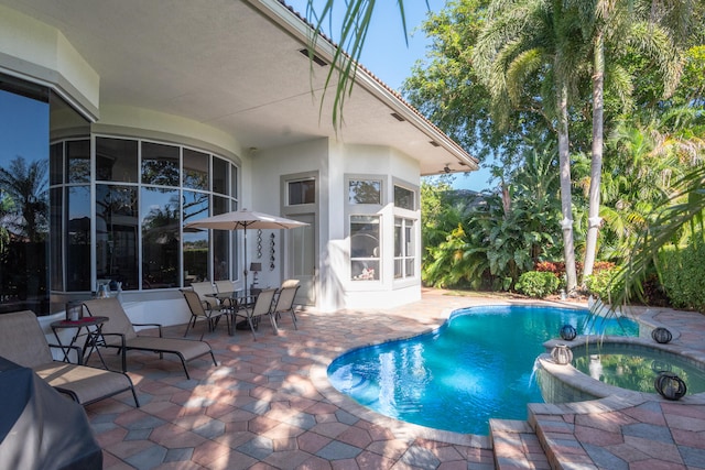 view of swimming pool featuring an in ground hot tub and a patio