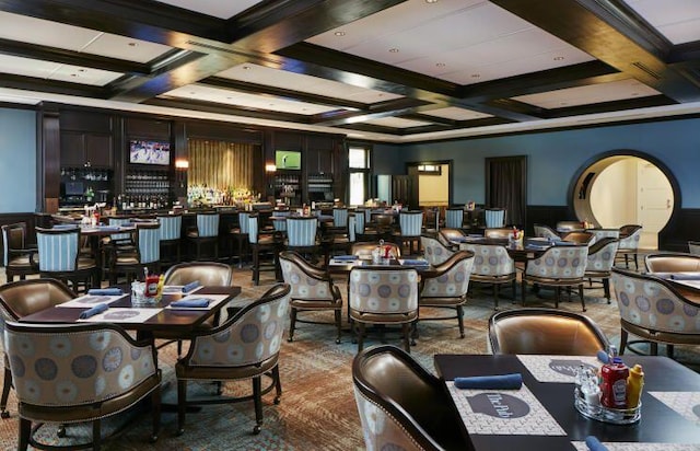 carpeted dining area featuring beamed ceiling and coffered ceiling