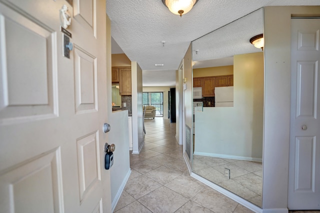 foyer featuring light tile patterned flooring and a textured ceiling