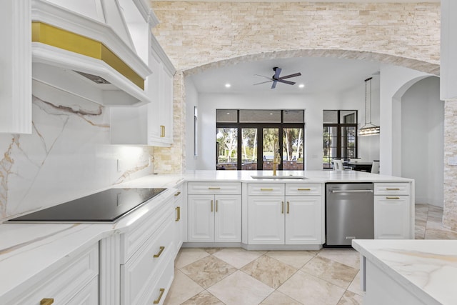 kitchen with light stone counters, black electric cooktop, a sink, white cabinetry, and a ceiling fan