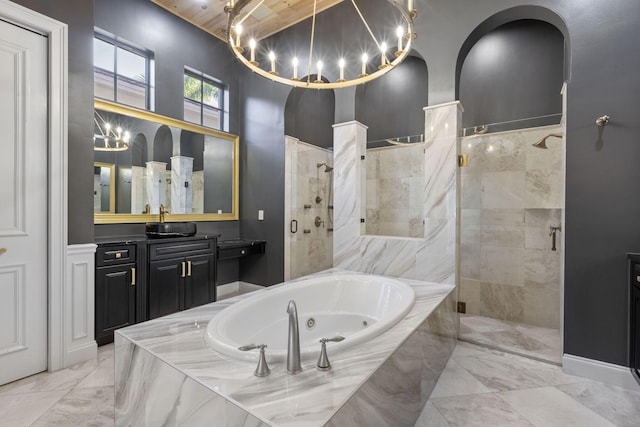 bathroom featuring a whirlpool tub, marble finish floor, a stall shower, and vanity