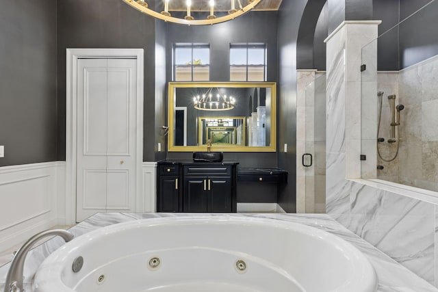 full bathroom featuring a tub with jets, wainscoting, a shower stall, and vanity