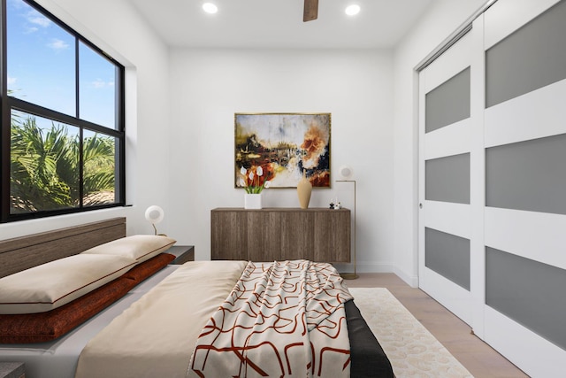 bedroom with light wood finished floors, ceiling fan, baseboards, and recessed lighting