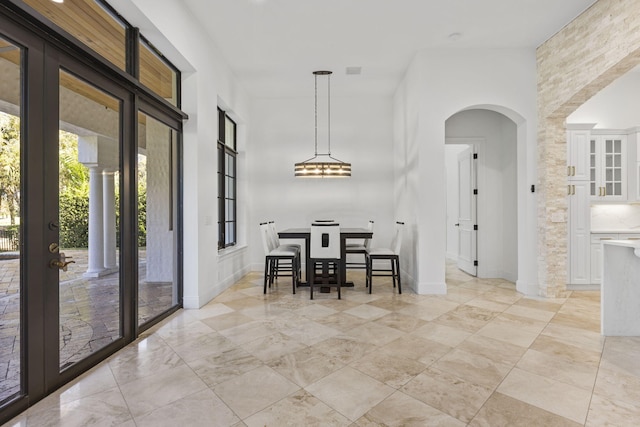 dining room with arched walkways and baseboards