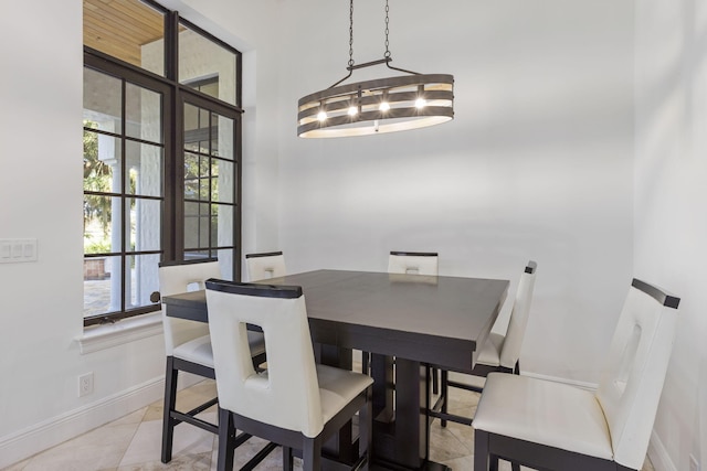 dining area featuring light tile patterned flooring and baseboards