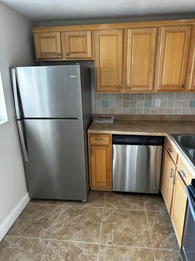 kitchen featuring decorative backsplash, stainless steel appliances, and sink