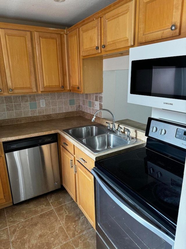 kitchen with sink, dishwasher, black range with electric cooktop, backsplash, and dark tile patterned flooring