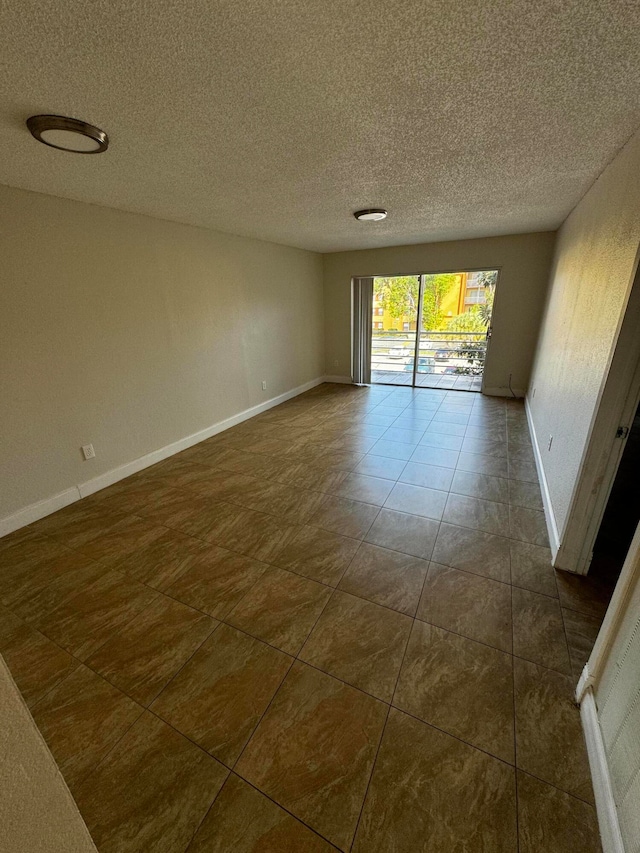 tiled spare room featuring a textured ceiling