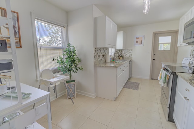 kitchen featuring white cabinets, stainless steel appliances, sink, and light tile patterned flooring