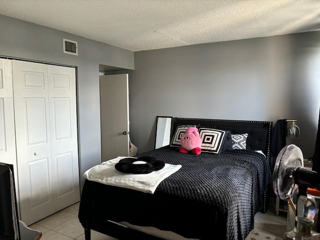 tiled bedroom featuring a textured ceiling and a closet