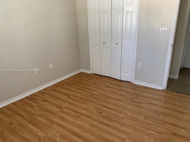 unfurnished bedroom with hardwood / wood-style floors and a closet