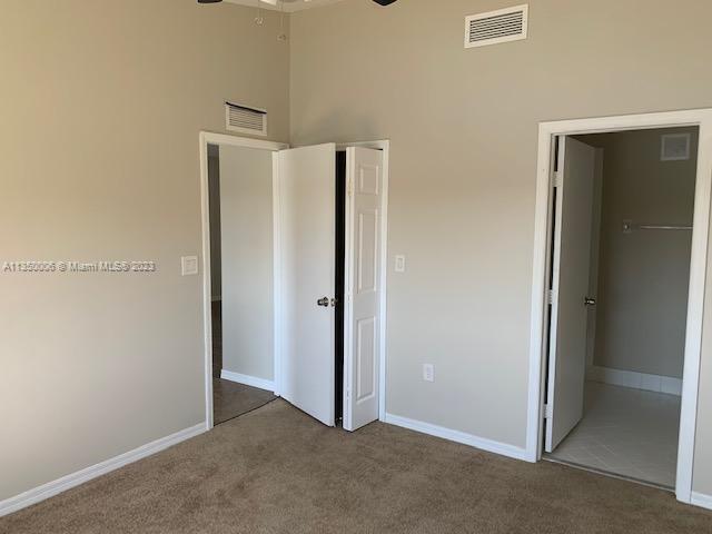 unfurnished bedroom featuring a towering ceiling and carpet floors