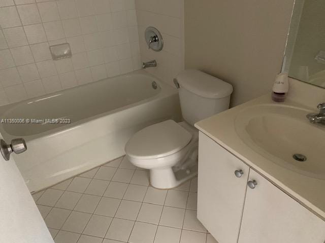 full bathroom featuring tile patterned flooring, vanity, toilet, and tiled shower / bath combo