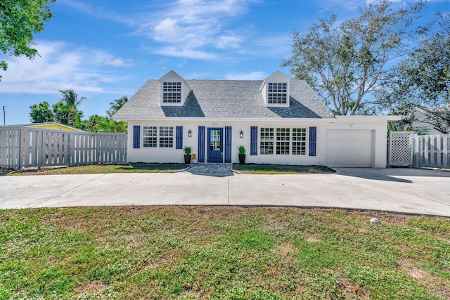 cape cod home with a front yard and a garage