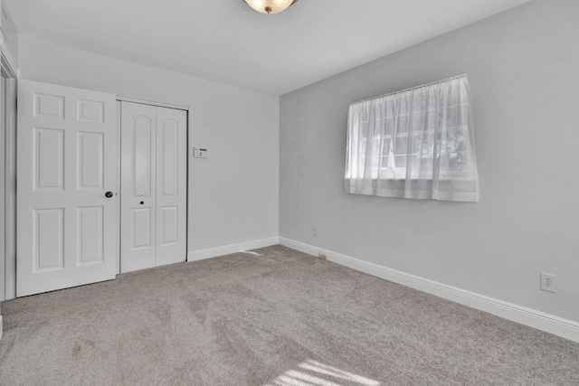 unfurnished bedroom featuring carpet flooring and a closet