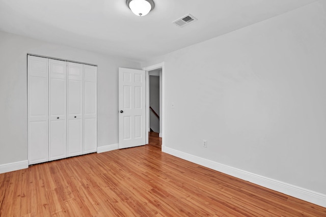 unfurnished bedroom featuring light hardwood / wood-style floors and a closet