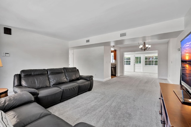 carpeted living room featuring a chandelier