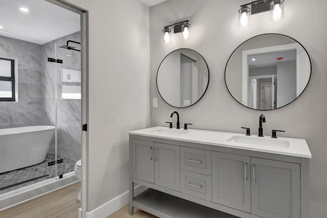 bathroom featuring hardwood / wood-style flooring, vanity, toilet, and walk in shower