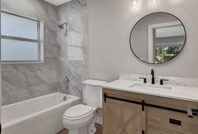 full bathroom with tiled shower / bath, toilet, and vanity