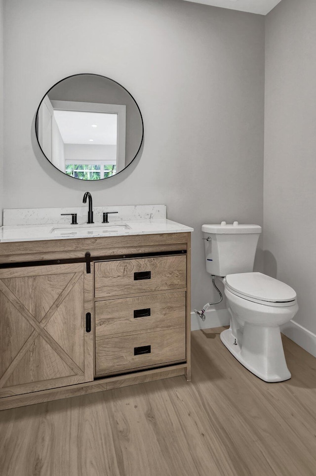 bathroom featuring hardwood / wood-style flooring, vanity, and toilet