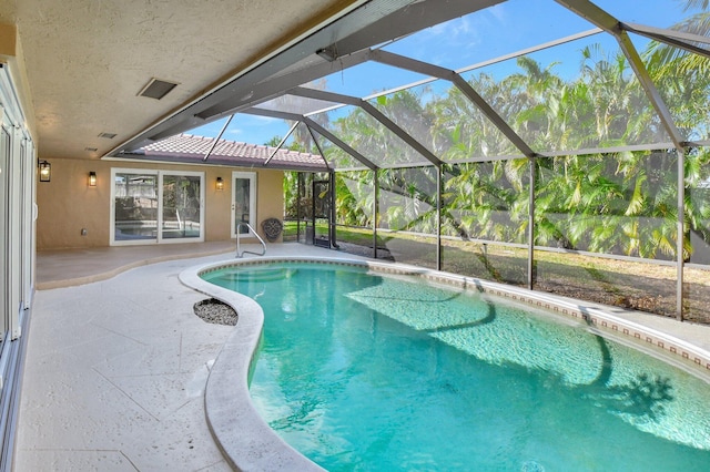 view of pool with a patio and glass enclosure