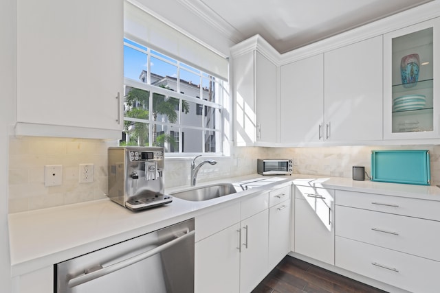 kitchen featuring dark wood-type flooring, sink, stainless steel dishwasher, tasteful backsplash, and white cabinetry