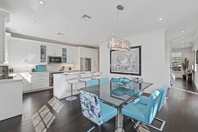 dining space with a chandelier, crown molding, and dark wood-type flooring