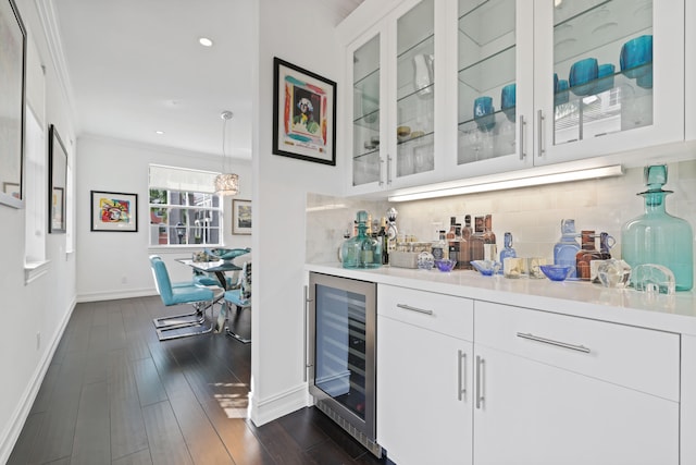 bar featuring wine cooler, crown molding, white cabinets, and dark wood-type flooring