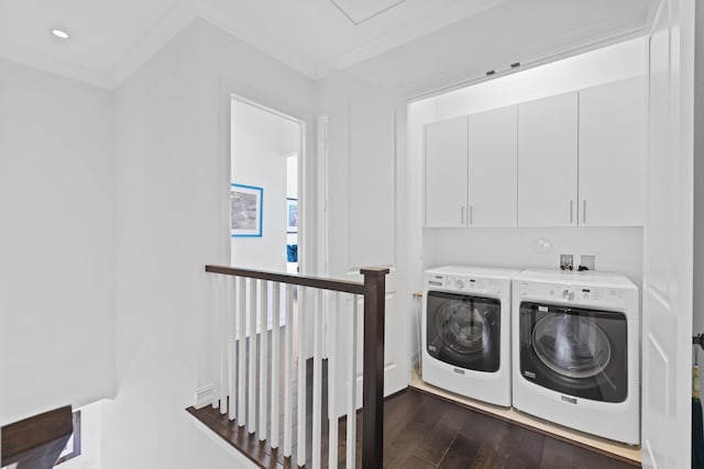 washroom featuring cabinets, washing machine and dryer, dark hardwood / wood-style floors, and crown molding