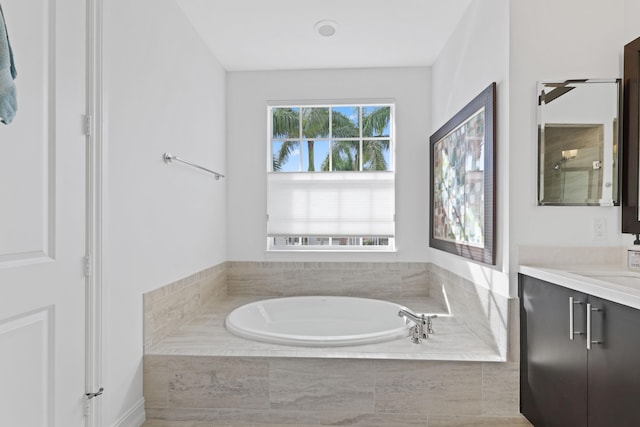 bathroom with vanity and a relaxing tiled tub