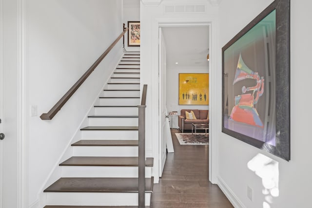 stairway featuring wood-type flooring and crown molding