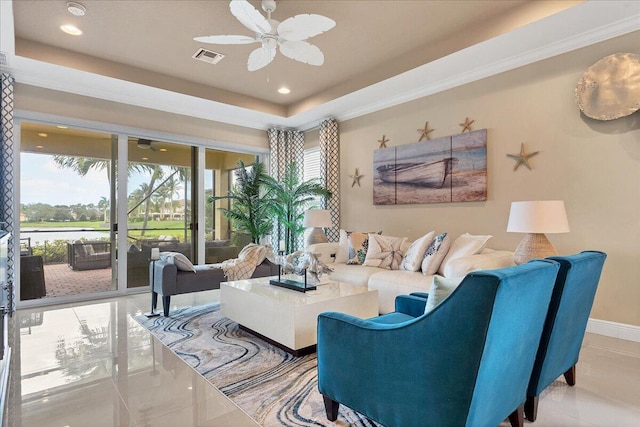 living room featuring a tray ceiling, a healthy amount of sunlight, ceiling fan, and visible vents