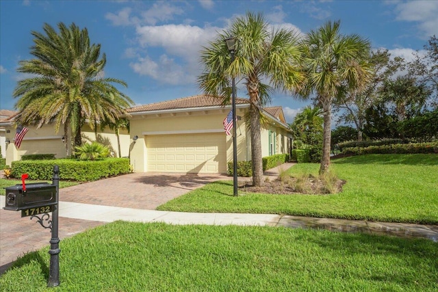 view of front of property with decorative driveway, stucco siding, an attached garage, a front yard, and a tiled roof