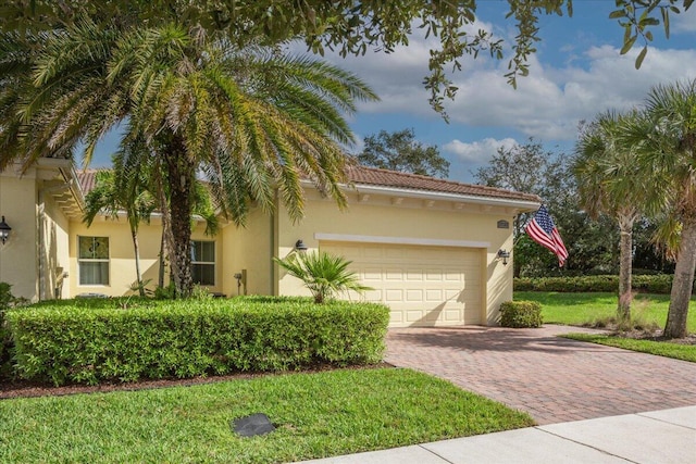 view of front facade with decorative driveway, an attached garage, and stucco siding