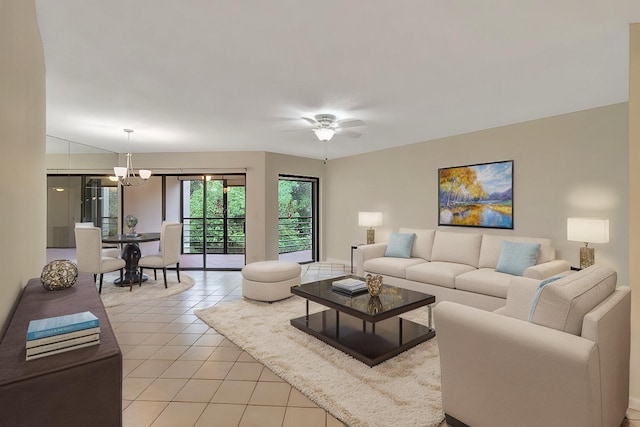 living room featuring ceiling fan with notable chandelier and light tile patterned floors