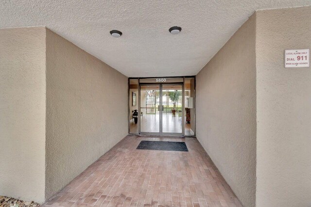 unfurnished room featuring a textured ceiling, ceiling fan with notable chandelier, and light tile patterned flooring