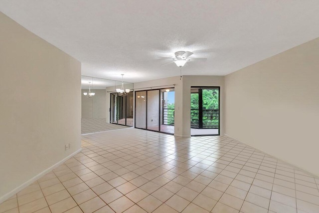 empty room with ceiling fan with notable chandelier, light tile patterned flooring, and a textured ceiling