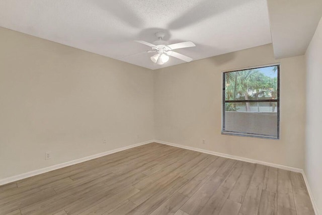 empty room with ceiling fan, a textured ceiling, and light hardwood / wood-style floors