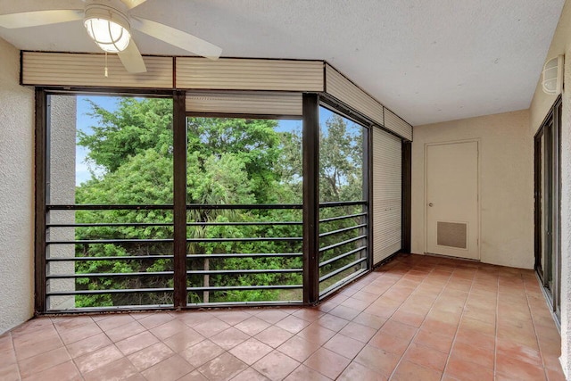 unfurnished sunroom with ceiling fan and a wealth of natural light